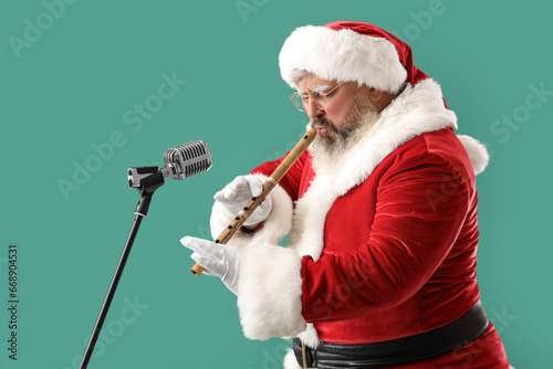 Cool Santa Claus with microphone and woodwind instrument on turquoise background photo