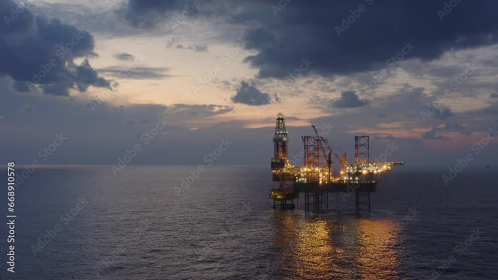 Aerial view of offshore jack up drilling rig during early night time - oil and gas industry Aerial view of offshore jack up drilling rig during early night time - oil and gas industry