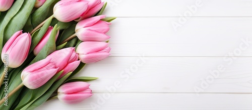 Top view of pink tulip bouquet on white wooden background copy space