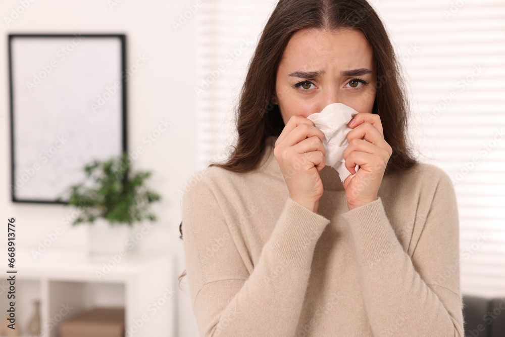 Sick woman with tissue blowing nose at home, space for text. Cold symptoms Sick woman with tissue blowing nose at home, space for text. Cold symptoms