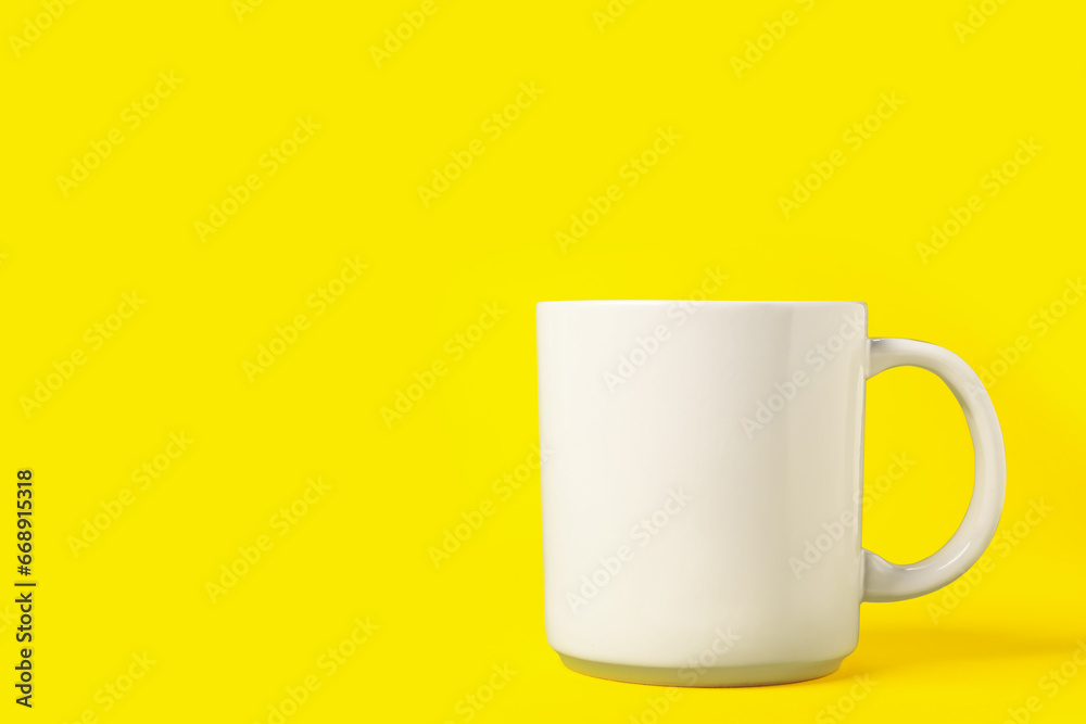 One white ceramic mug on yellow background, space for text One white ceramic mug on yellow background, space for text
