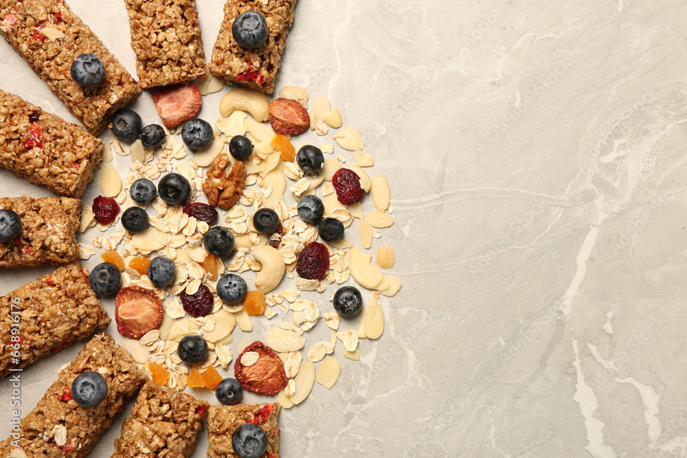 Tasty granola bars and ingredients on beige marble table, flat lay. Space for text