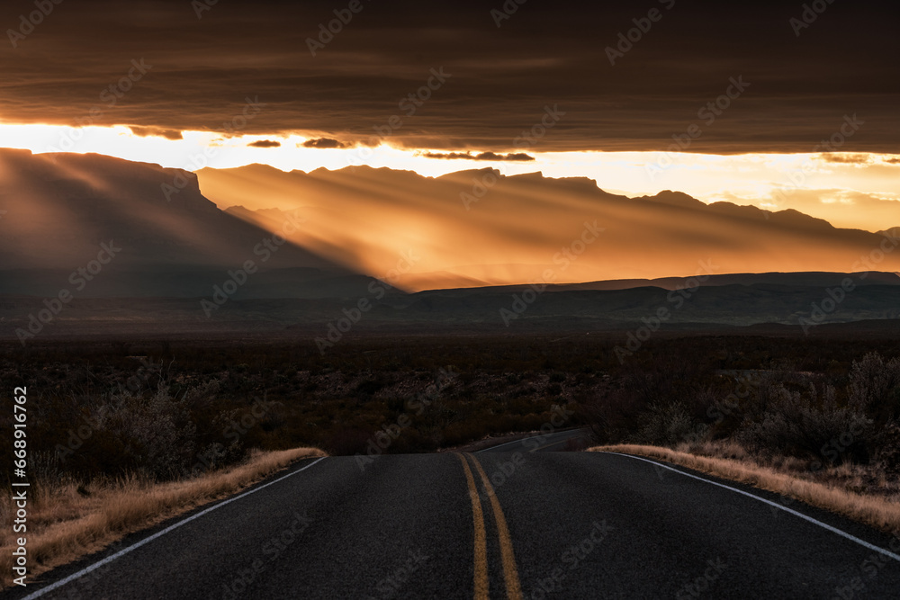Road Bends Over Hill Below Dramatic Sun Rise Rays
