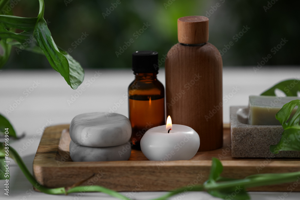 Beautiful composition with different spa products and green leaves on white table, closeup Beautiful composition with different spa products and green leaves on white table, closeup