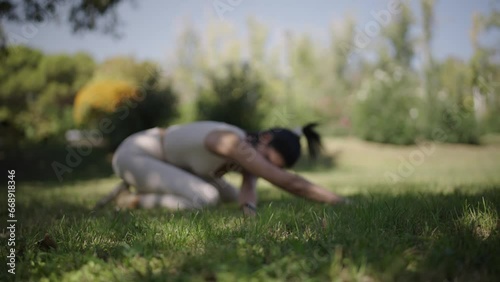 young woman stretching her body in a park on a sunny day