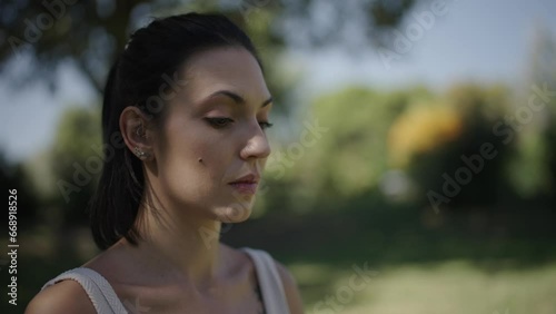 portrait of a woman looking around and breathing consciously in an open-air park