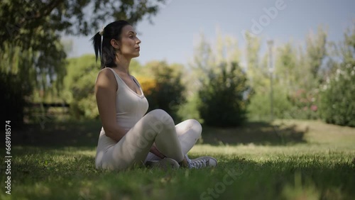 young woman stretching her body in a park on a sunny day