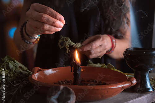 woman doing traditional ritual with black candle sea salt pepper in clay plate with herbs and incense and energy management with fire