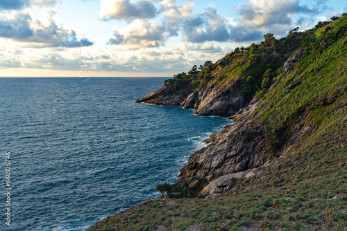 Landscape with rocky coast hills cliffs and dark blue sea with crashing waves, Phuket Thailand.