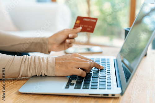 Close up credit card using for online payment, banking and shopping on the internet network with laptop computer showing credit card technology for online secured wallet top up and crucial purchase