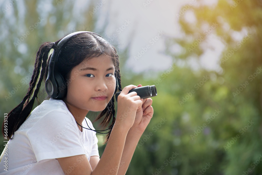 Asian cute girl holds binoculars to watch birds in the forest, birds and nature study concept. Asian cute girl holds binoculars to watch birds in the forest, birds and nature study concept.