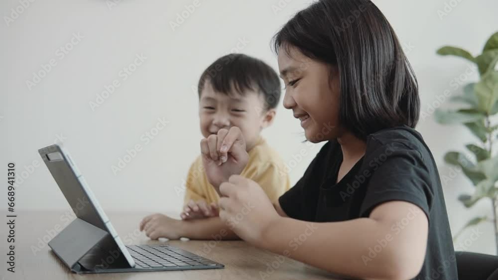 Asian children looking at digital tablet. E-learning technologies and sibling relationship. Asian children looking at digital tablet. E-learning technologies and sibling relationship.