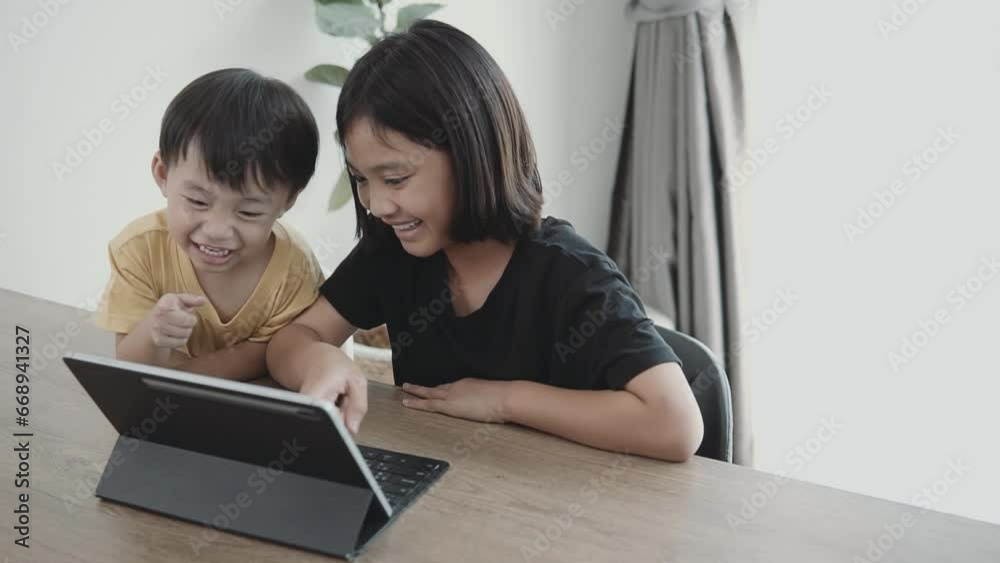 Asian children looking at digital tablet. E-learning technologies and sibling relationship. Asian children looking at digital tablet. E-learning technologies and sibling relationship.