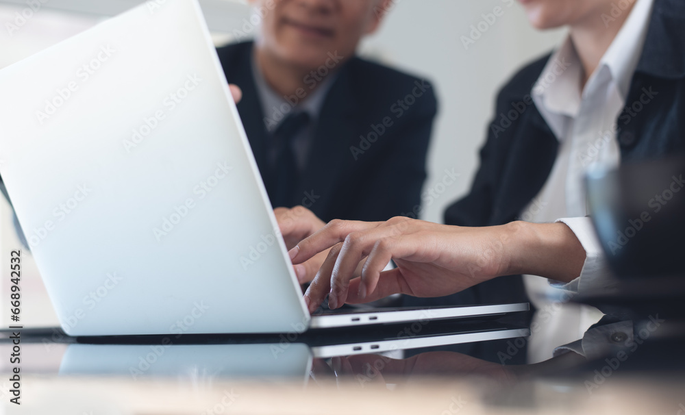 Two asian business colleagues working together. Businessman brainstorming, having a discussion about work project, working on laptop computer at modern office. Business teamwork Two asian business colleagues working together. Businessman brainstorming, having a discussion about work project, working on laptop computer at modern office. Business teamwork