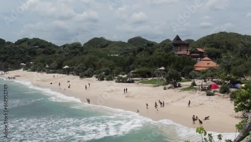 The video showcases the picturesque Gunungkidul Beach in Indonesia, renowned for its white sandy shores, clear waters, limestone cliffs, and serene atmosphere, making it a perfect for nature lovers
