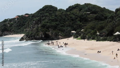 The video showcases the picturesque Gunungkidul Beach in Indonesia, renowned for its white sandy shores, clear waters, limestone cliffs, and serene atmosphere, making it a perfect for nature lovers