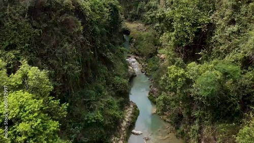 Kali Suci in Gunungkidul, Indonesia, is a pristine river known for its crystal-clear waters, nestled amidst rugged cliffs and lush vegetation.