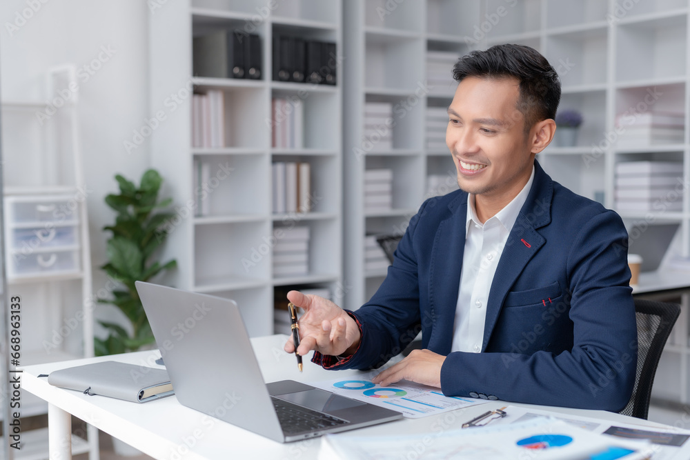 Asian businessman having conference video call using laptop talking to coworker online audience sitting at office. Consultation, webinar, tutoring on internet, telecommuting. Asian businessman having conference video call using laptop talking to coworker online audience sitting at office. Consultation, webinar, tutoring on internet, telecommuting.