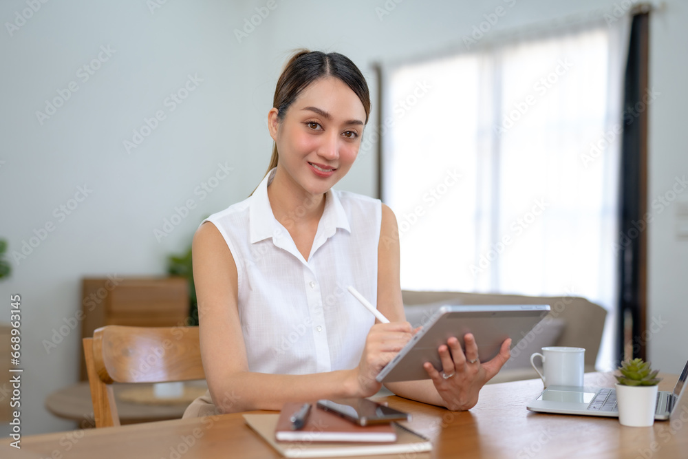 Young asian woman using digital tablet while sitting at home. Young asian woman using digital tablet while sitting at home.
