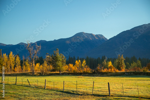 Montana fenced farm in autumn with rocky mountains in the background