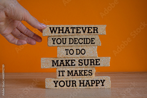 Concept words Whatever you decide to do, make sure it makes you happy. Words on brick blocks. Beautiful wooden table orange background. Businessman hand. Inspirational motivation quote.