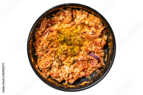 Turkish Menemen omelet in a frying pan. Black background. Top view