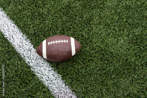 Football by a yard marker on a football field