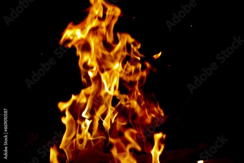 Bright golden orange flames against black background with copy space