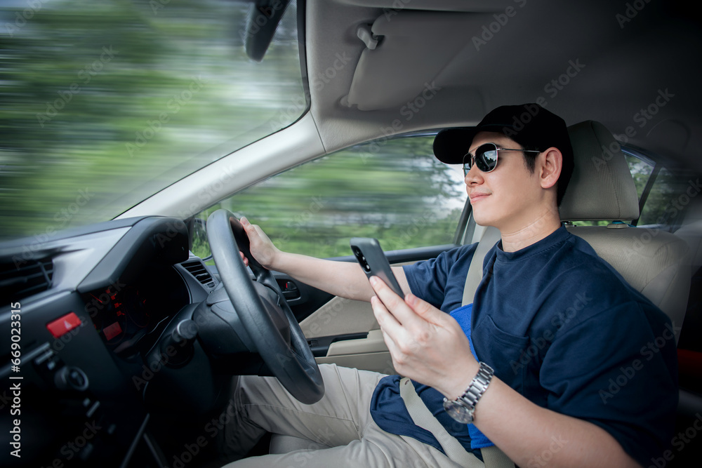 Naklejka premium Asian man on vacation smiles happily holding a smartphone to open online map to find new route while heading to a vacation destination. concept of traveling to find inspiration and safety in traveling