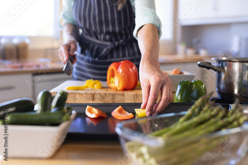 Midsection of senior caucasian woman cooking dinner in kitchen photo