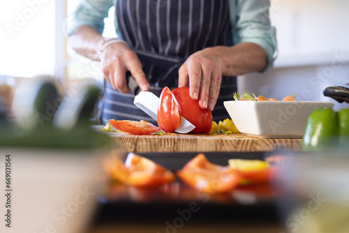 Midsection of senior caucasian woman cooking dinner in kitchen photo