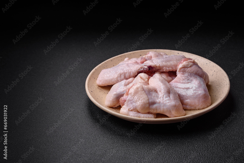 Fresh raw chicken wings with salt and spices prepared for baking Fresh raw chicken wings with salt and spices prepared for baking