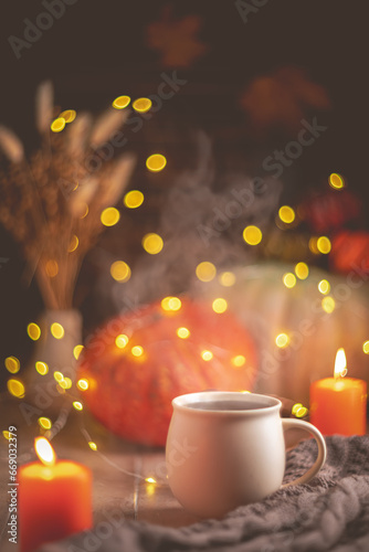 Autumn cozy composition. Tea in a mug, pumpkins and candles