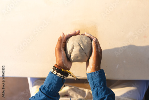 Hands of african american potter shaping clay with hands in pottery studio photo