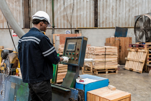 Black worker man working with machine in wood warehouse