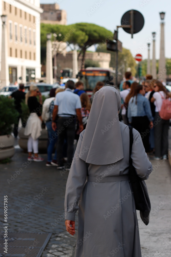 Nun walking in a steet of Rome