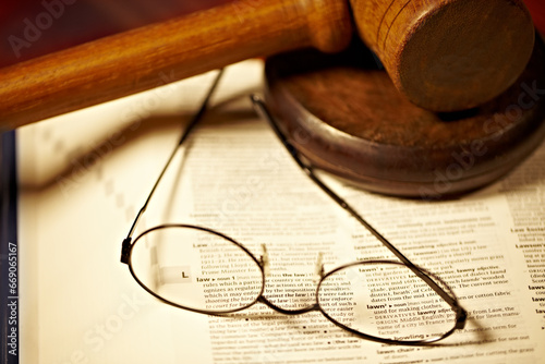 Table, law and a report, glasses and gavel for a court decision, notes or a justice report. Closeup, desk and paperwork or a dictionary for legal knowledge, courtroom words or a crime defense