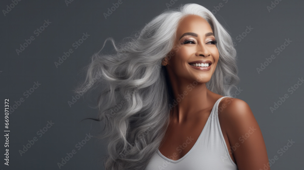 Sensual middle-aged beautiful Asian woman with long grey hair, her eyes closed, body and face care concept. Charming mature lady stands in profile isolated on grey studio background Sensual middle-aged beautiful Asian woman with long grey hair, her eyes closed, body and face care concept. Charming mature lady stands in profile isolated on grey studio background