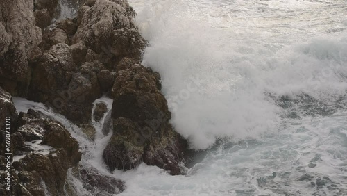 Slow motion sea waves crushing over rocks with soft light photo