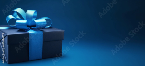 luxury gift box with a blue bow on blue, side view monochrome, Fathers day or Valentines day gift for him, Corporate gift concept or birthday party photo
