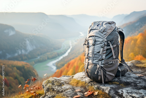 Close up of hiking backpack on stone in background of autumn mountains. Travel concept of vacation and holiday. © cwa