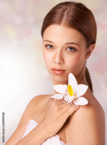 Woman, portrait and flower for wellness in studio, beauty and skincare for care, elegant and cosmetic. Female model person, floral and brunette or spa treatment, organic body care and background