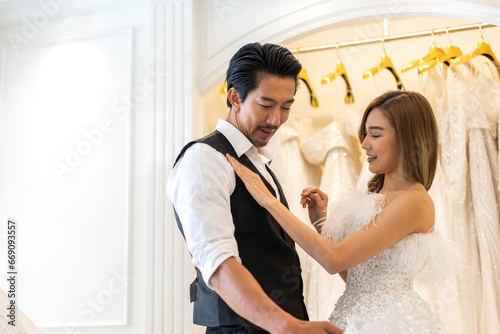 Portrait of smiling cheerful happy love asian couple fashion bride man and woman posing in white wedding dress for pre wedding hug together at wedding interior fashion studio