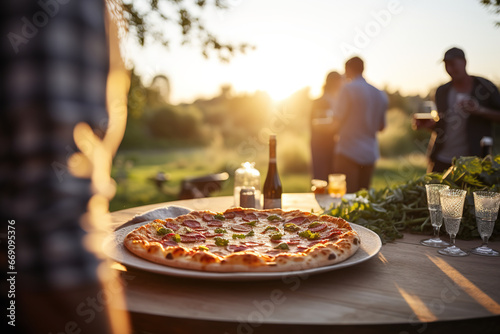 Outdoor pizza party at sunset, beautiful warm back-light around the pizza, making the cheese shine