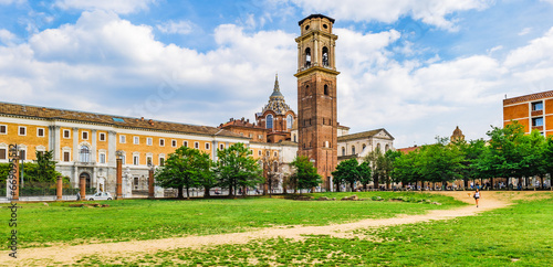Turin, Italy. View of the building of  Galleria Sabauda Museum. In the centre, the bell tower of the cathedral of San Giovanni Battista. In foreground a lawn of the Porta Palatina Park. 2023-05-04. photo