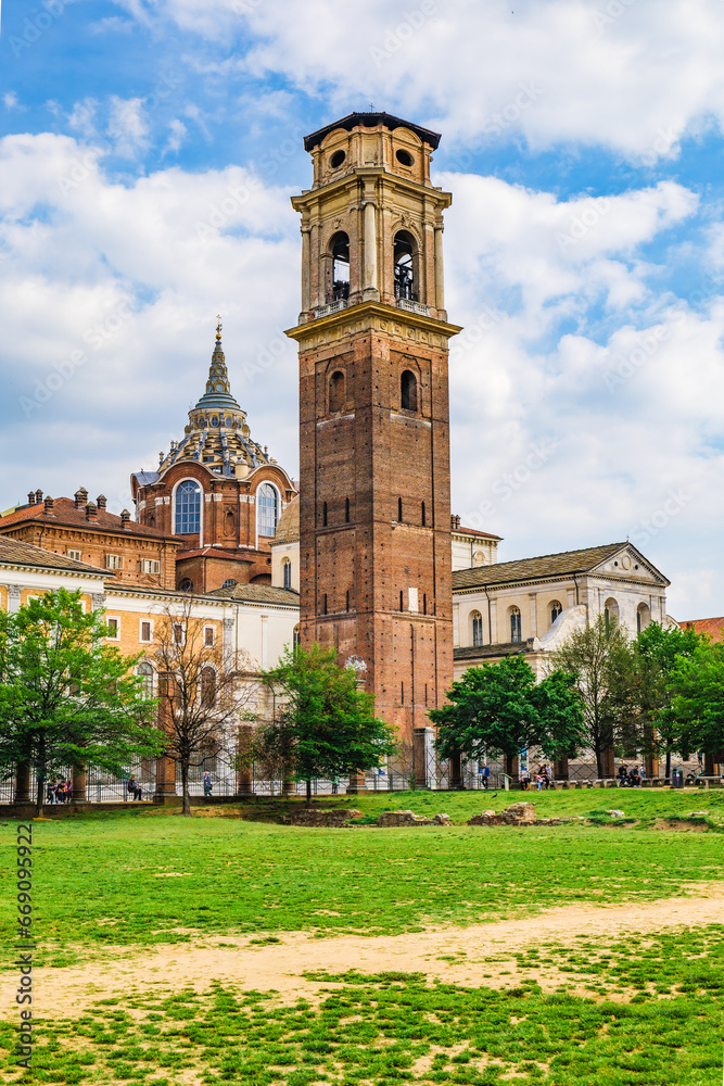 Turin, Italy. View of the bell tower of the cathedral of San Giovanni Battista. In foreground a lawn of the Porta Palatina Park. 2023-05-04.