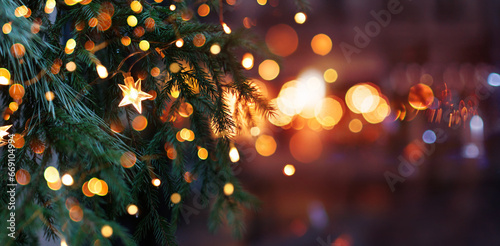 Christmas tree with garland lights. Evening city with blurred background and bright lights