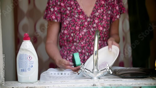 homemaker cleaning dishes using sponge 