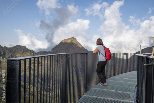 Obraz na plátně young curvy caucasian girl enjoying the views leaning on the railing of the tris