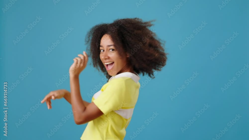 Happy African-American woman dances walking past on blue Happy African-American woman dances walking past on blue
